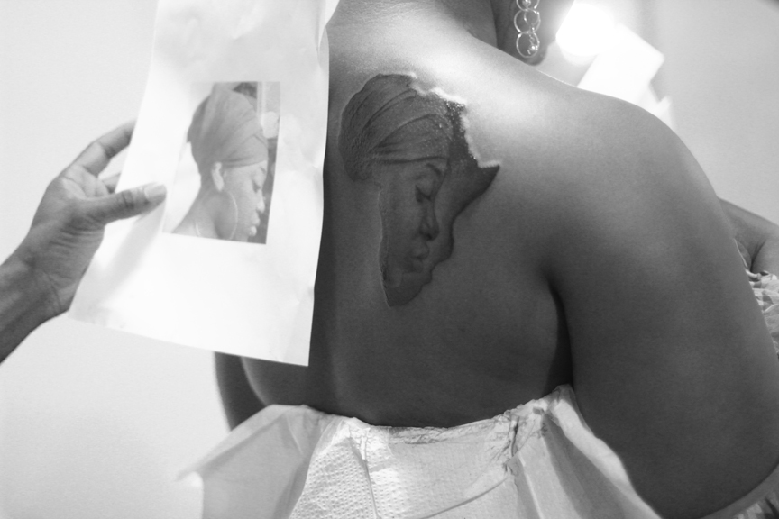 African Queen Face In Map Tattoo On back