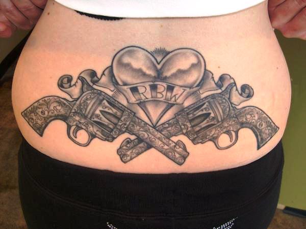 Amazing Crossed pistols with heart tattoo on girl's back