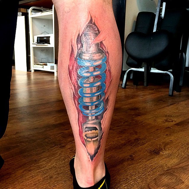 Amazing Shock Absorber Tattoo On Leg By Karl Joyce