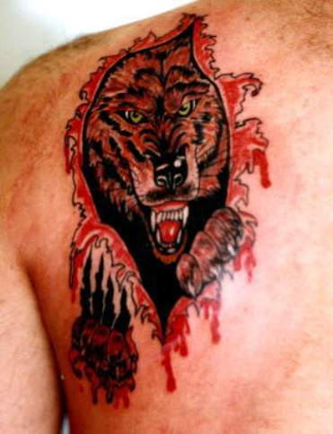Angry wolf coming out of ripped skin tattoo on shoulder back