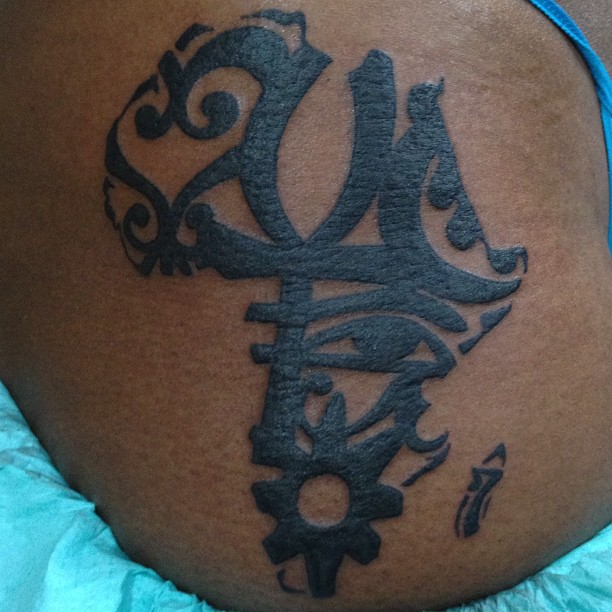 Black ink African Symbols in the form of African map tattoo
