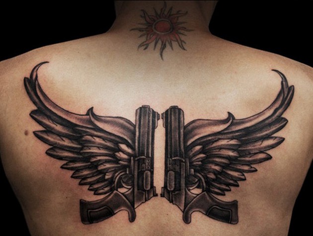 Black ink pistols with wings tattoo on back giving peace over war message