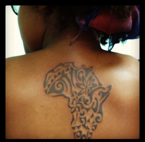 Black ink tribal designed African map tattoo on girl's upper back