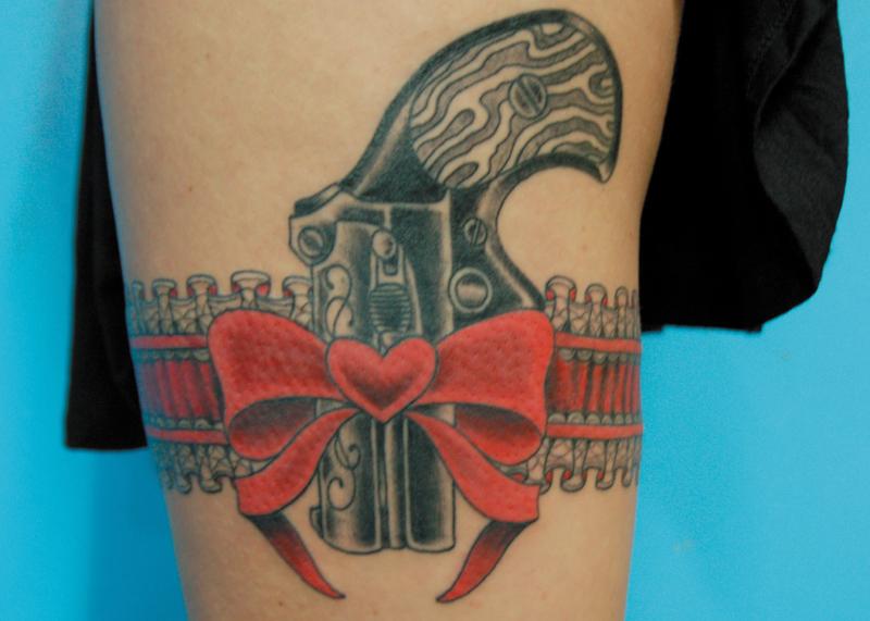 Cute pistol in red and grey garter tattoo