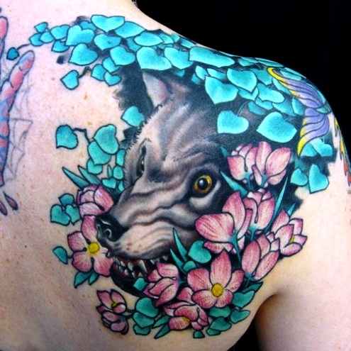 Dark wolf with colorful leaves and flowers tattoo on shoulder's back