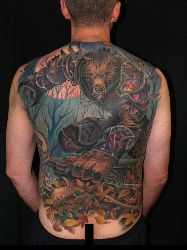Evil faced angry wolf with skull, bones and leaves tattoo on back by Clay McCay representing wildness and strength