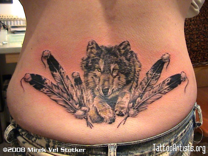 Jumping wolf & feathers tattoo on lower back by Mirek vel Stotker