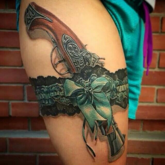 Old fashioned pistol in stylish lace garter belt tattoo