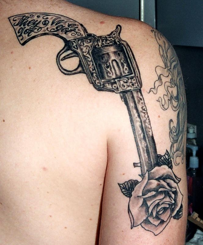 Old pistol and rose tattoo on back