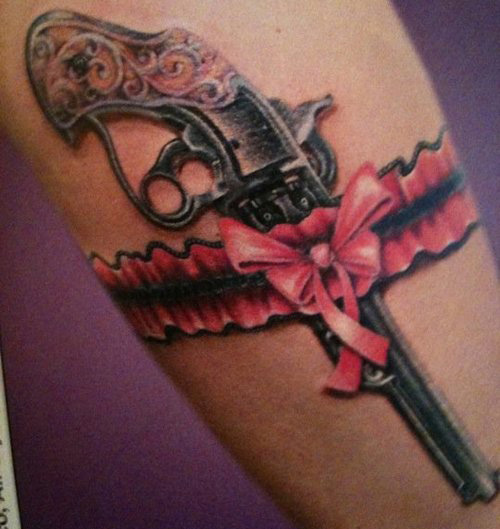 Old pistol with ribbon tattoo