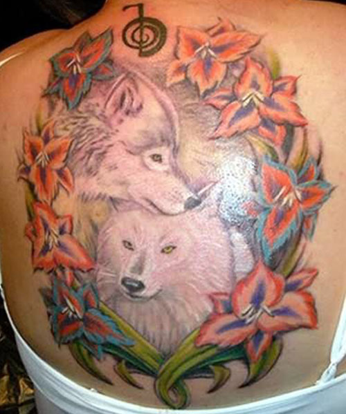 Wolves couple with peaceful & loving face expressions surrounded by beautiful flowers tattoo on back