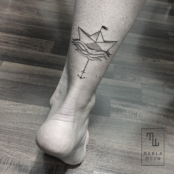 Black ink paper boat with anchor tattoo on calf