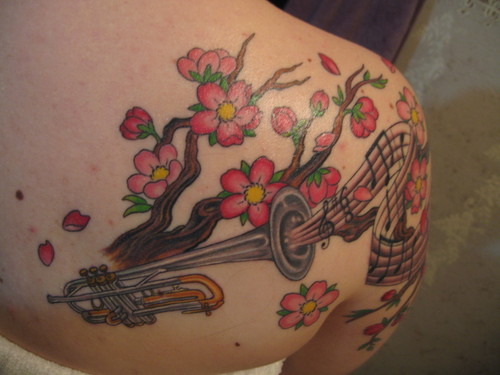Cherry Blossoms with Trumpet Tattoo on girl’s back