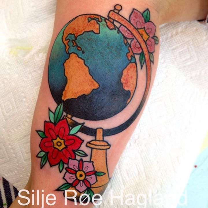 Colorful globe tattoo on bicep by Silje