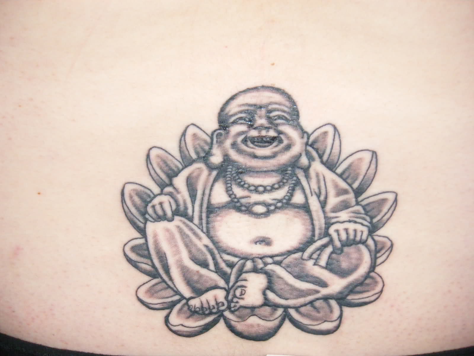 Laughing Buddha Sitting In Lotus Flower Tattoo