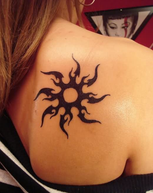 Tribal sun tattoo on girl’s back shoulder