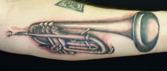 Trumpet tattoo on forearm by Daniel James Walker