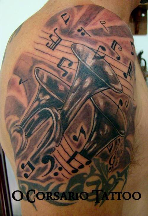Trumpet with musical symbols tattoo on shoulder