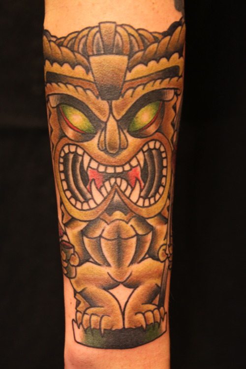 Brown Ink Tiki Tattoo On Arm
