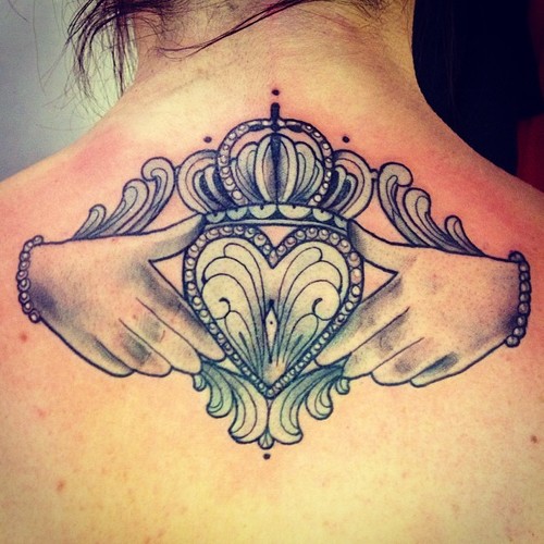 Claddagh tattoo on upper back