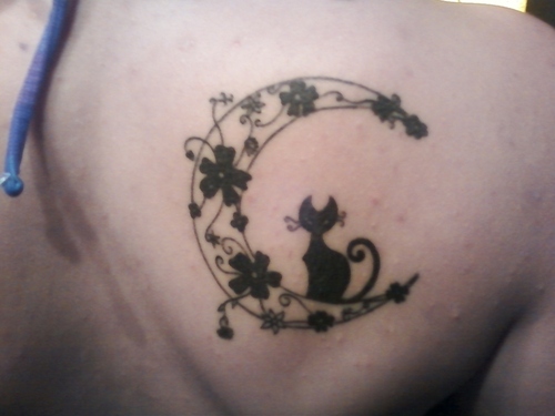 Crescent moon with black tattoo on right back shoulder