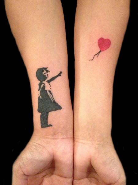 Nice banksy girl tattoo on girl forearms