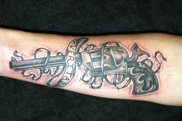 Pistol Tattoo With Veritas Banner Tattoo On Arm