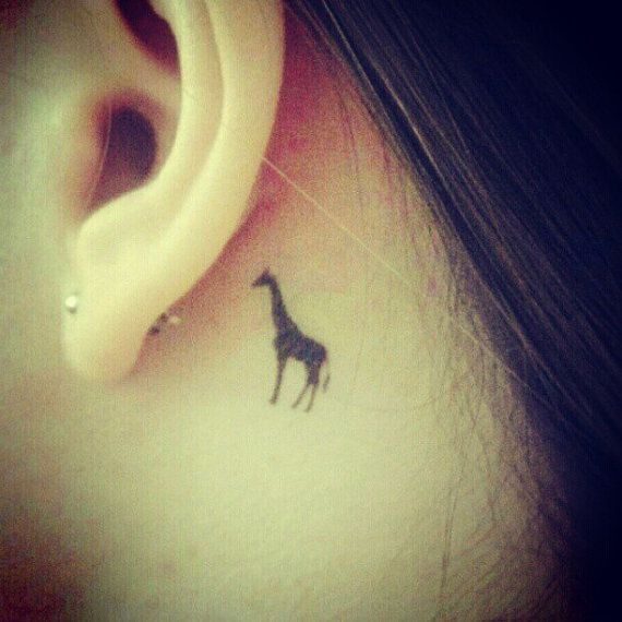 Black small Giraffe Tattoo behind the ear