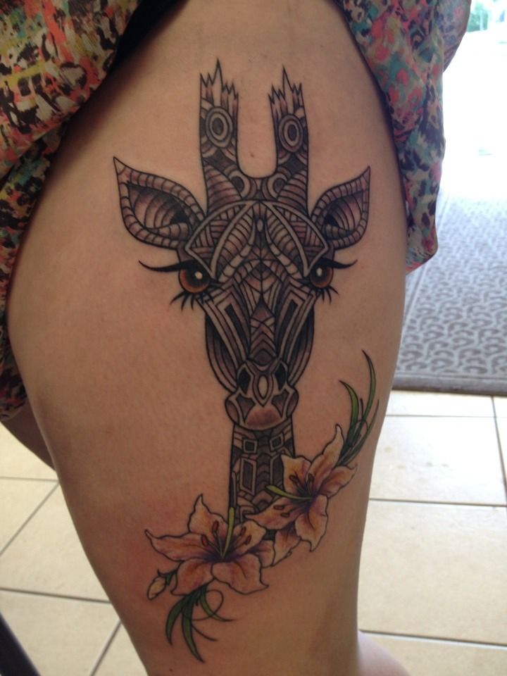 Giraffe head tattoo with flowers on thigh by Stacey Sharp