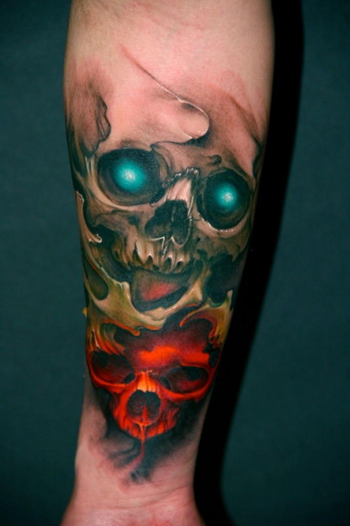 Green eyed colorful skull tattoo on forearm