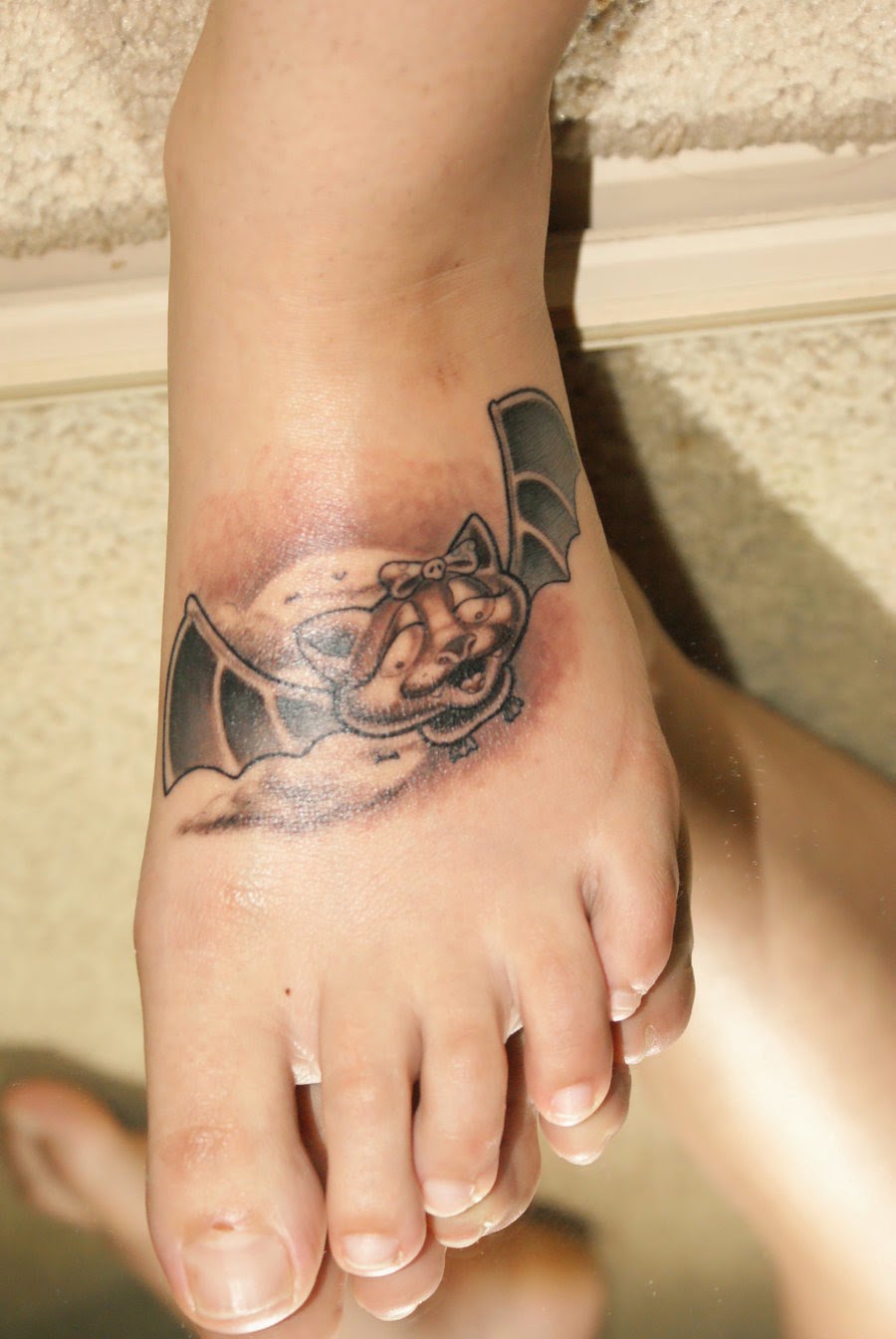 Black Smiling Flying Bat Tattoo On Foot By Oui Je Comprends
