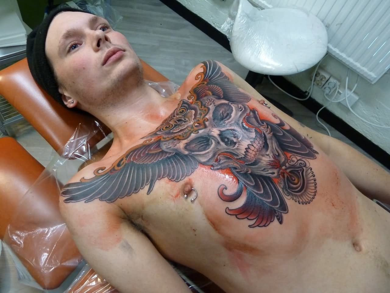 Colorful Skull With Flying Owl Tattoo On Man Chest