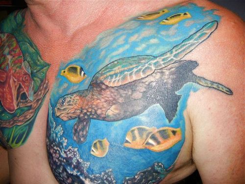 Colorful Turtle In Ocean Tattoo On Man Chest
