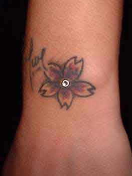 Flower Tattoo And Dermal Anchor Tattoo On Wrist