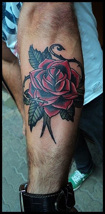 Red rose with leaves tattoo on forearm