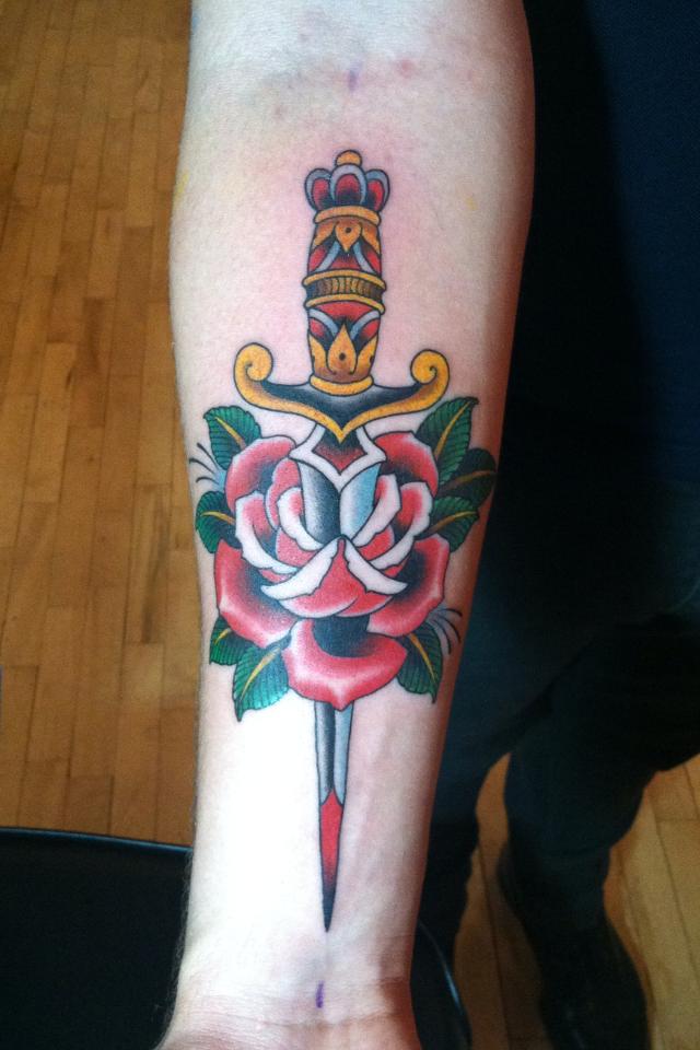 Amazing Colorful Dagger In Red Rose Tattoo On Forearm