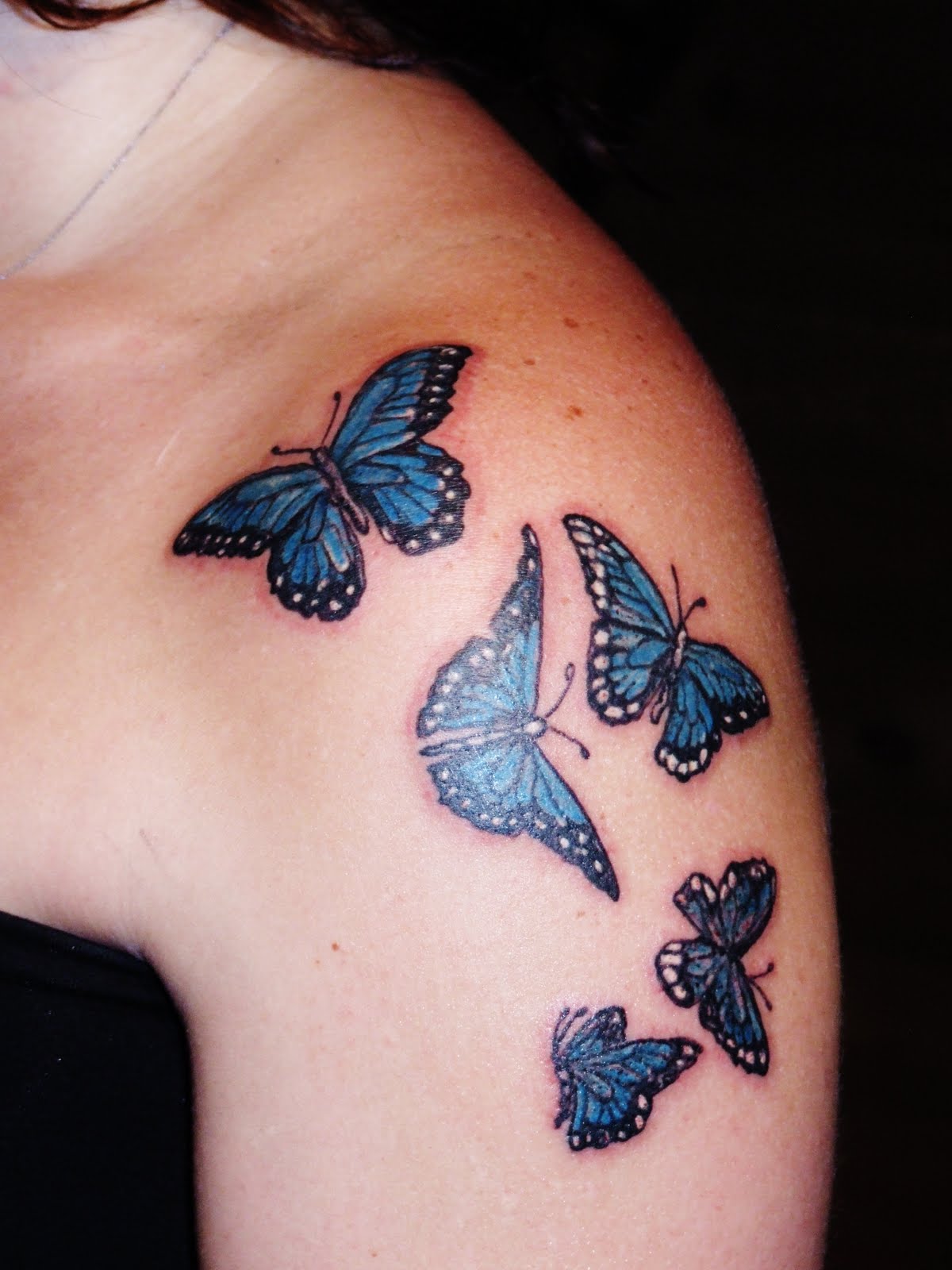 Black And Blue Butterflies Tattoo On Girl Left Shoulder