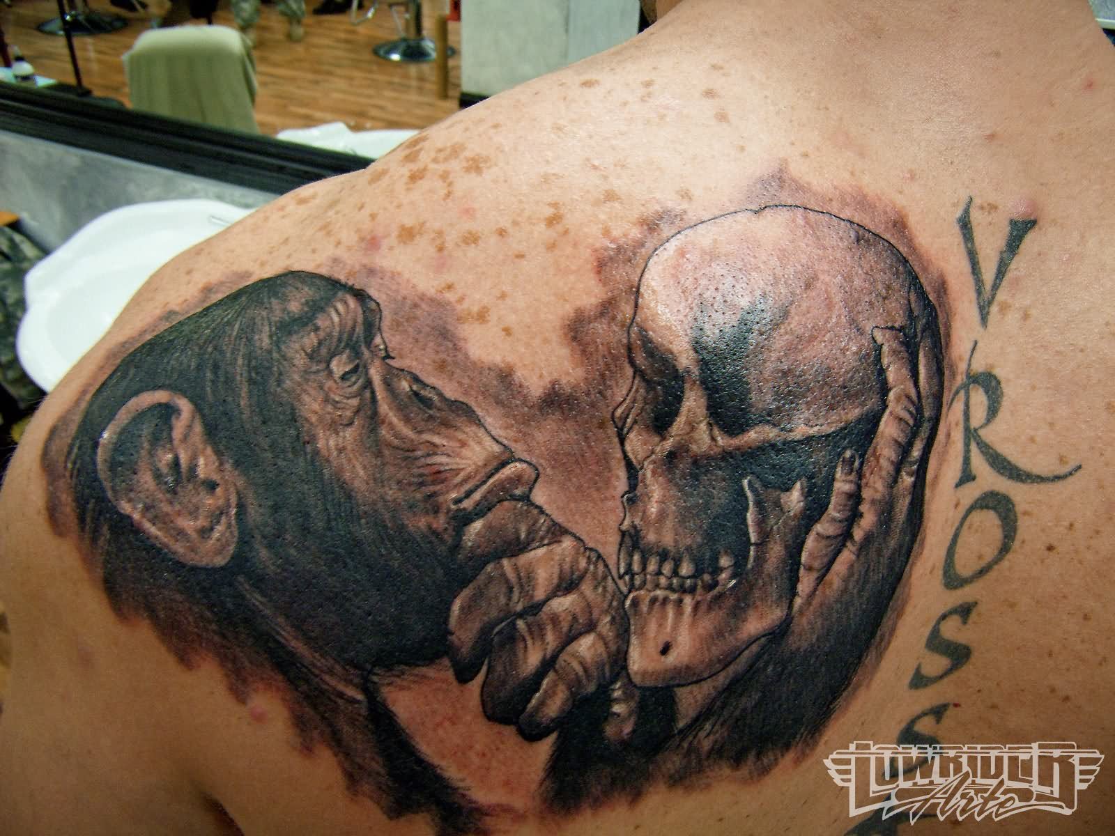 Black And Grey Skull On Monkey Hand Tattoo On  Left Back Shoulder