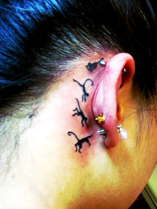 Black Little Four Monkey Tattoo On Behind The Ear