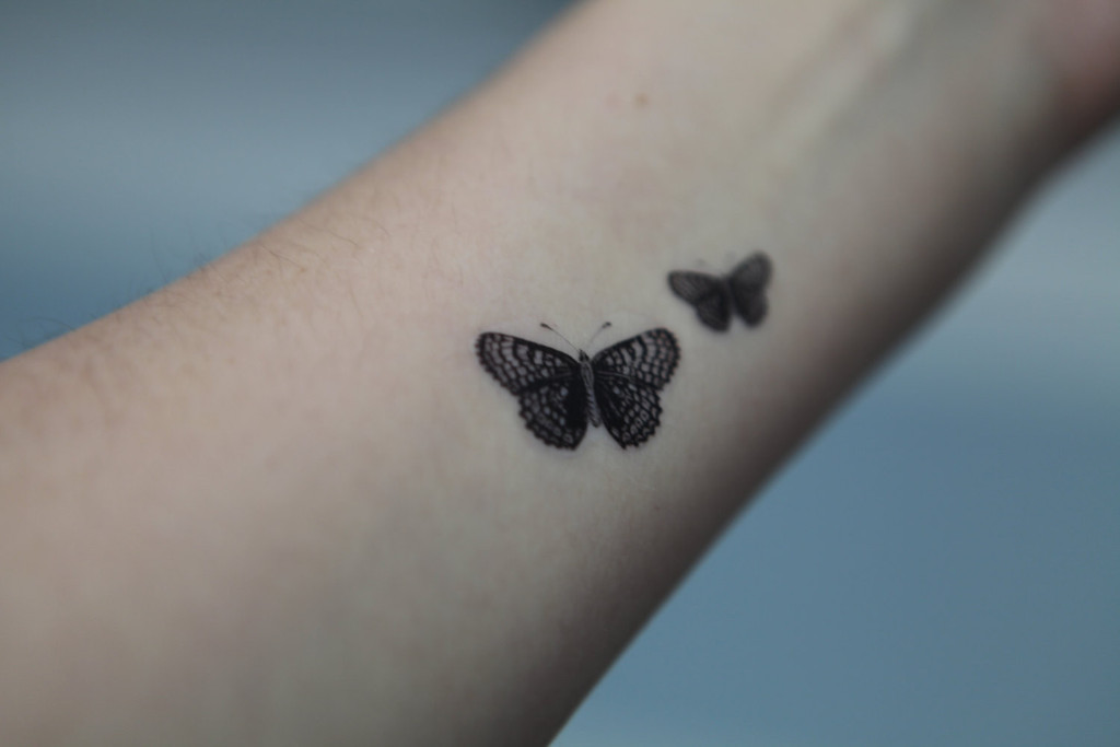 Black Two Little Butterflies Tattoo On Forearm
