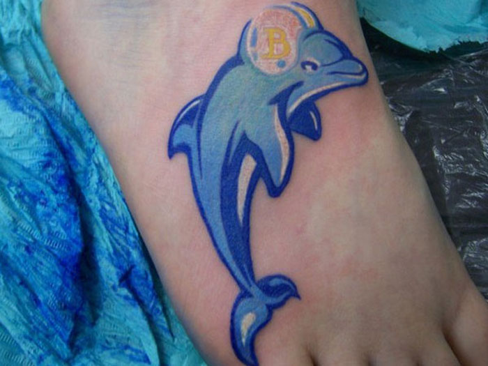 Blue Dolphin With Helmet Tattoo On Right Foot