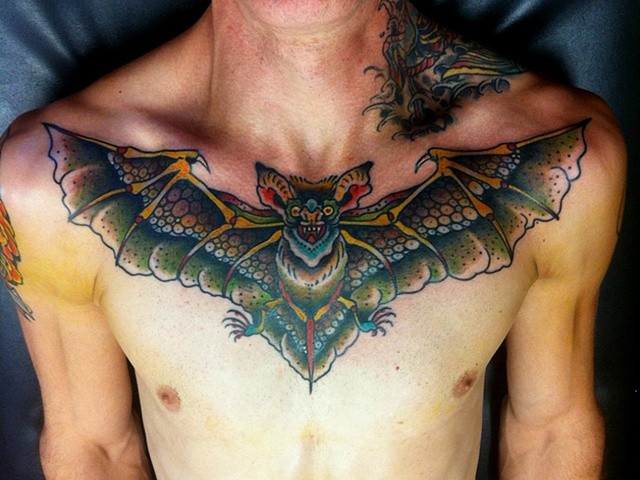 Colorful Flying Bat Tattoo On Man Chest