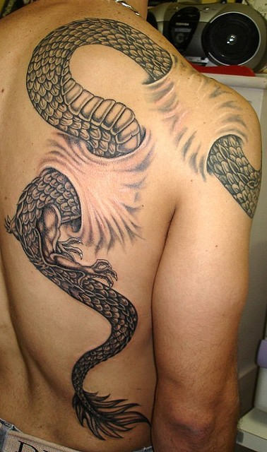 Ripped Skin Black Snake Tattoo On Man Back And Shoulder