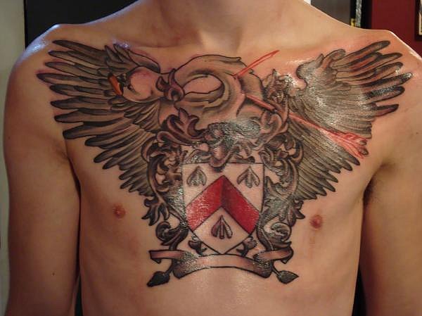 Awesome Family Crest With Wings Tattoo On Man Chest By Steve Vinall