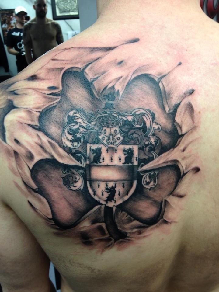 Black And Grey Ripped Skin Family Crest Tattoo On Man Back Shoulder