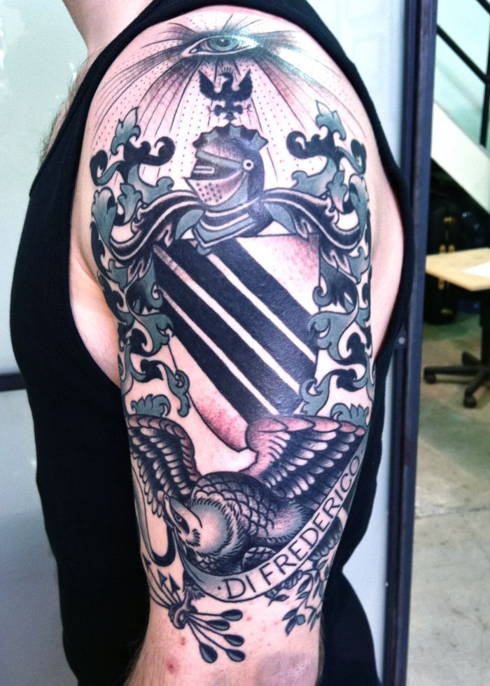 Black And Grey Warrior Mask With Family Crest Tattoo On Half Sleeve By Virginia Elwood