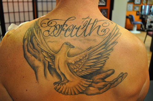 Black Faith With Flying Dove Tattoo On Upper Back
