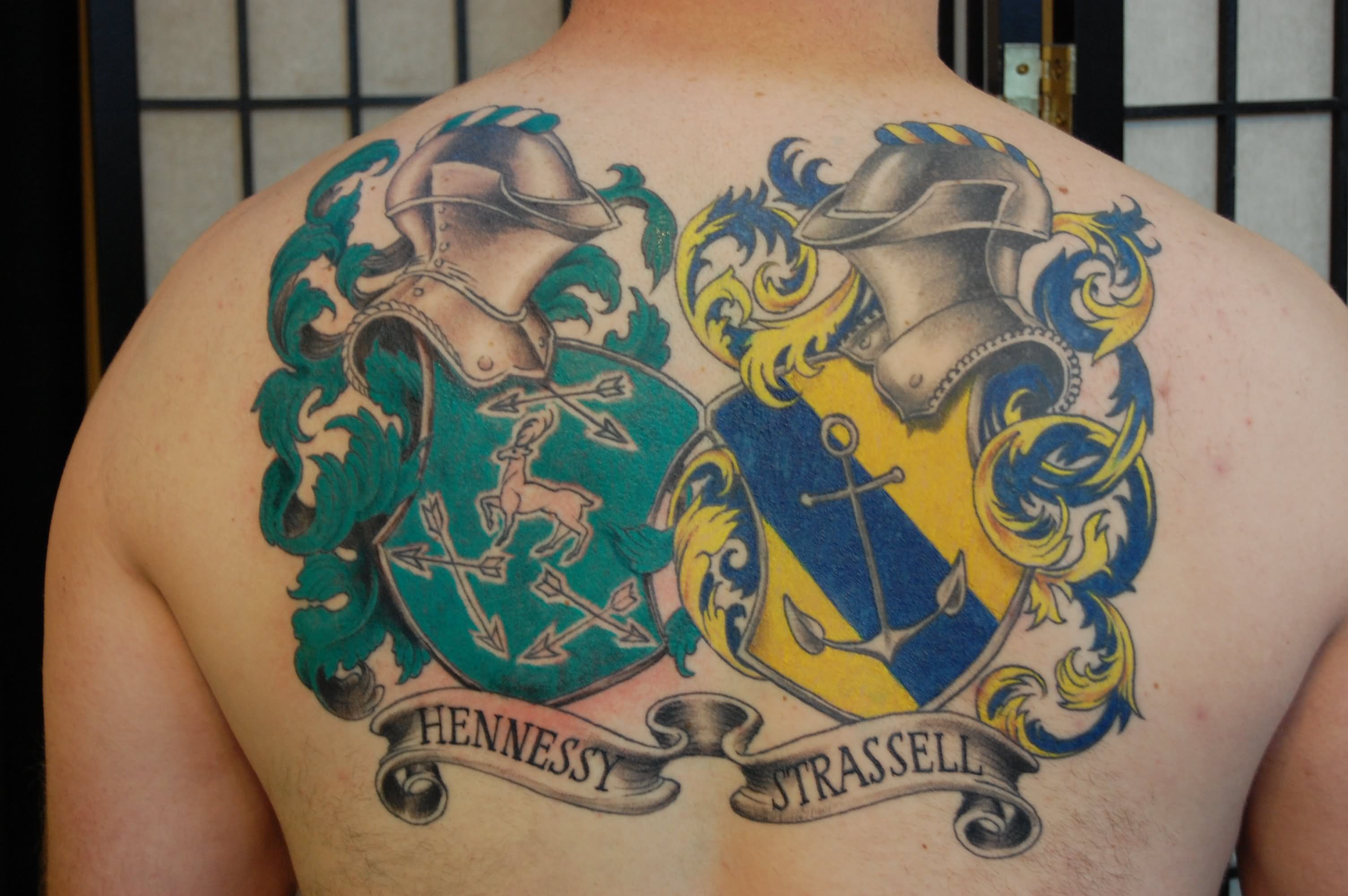 Colorful Deer And Anchor In Two Family Crest Tattoo On Man Upper Back