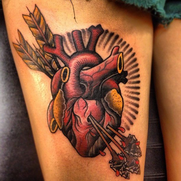 Real human heart pierced with arrows tattoo on thigh