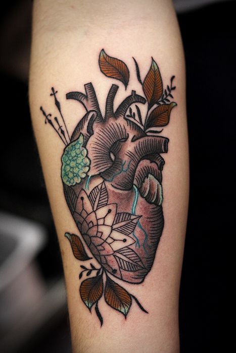 Real human heart with leaves tattoo on forearm